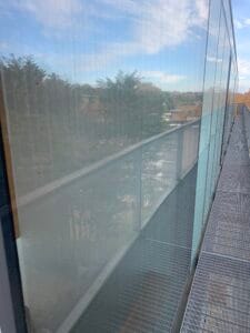 Glass panel showing water marks and dirt before cleaning